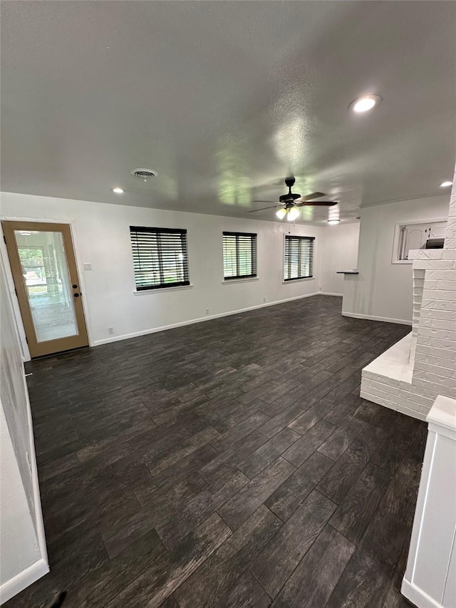 1911 College St, Gainesville, TX 76240 - unfurnished living room featuring a ceiling fan, dark wood finished floors, recessed lighting, baseboards, and a fireplace