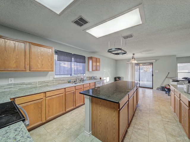 kitchen with a kitchen island, light tile patterned flooring, sink, range with electric stovetop, and a textured ceiling