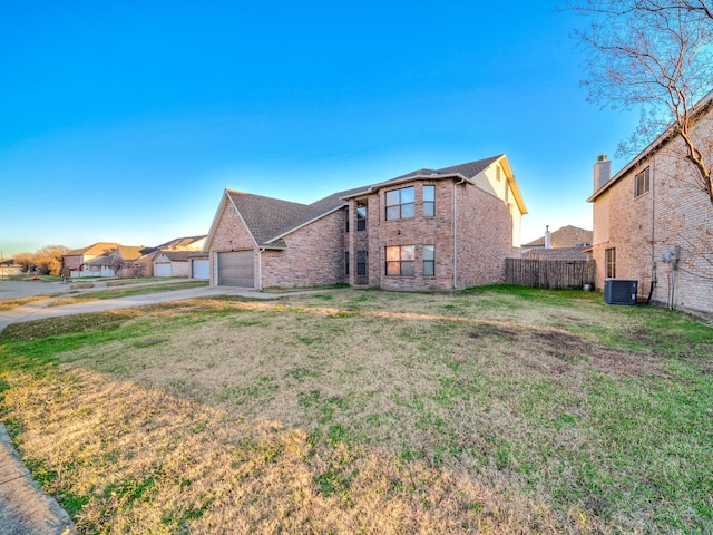 view of front of home featuring a front yard, cooling unit, and a garage