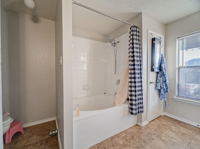 bathroom featuring a textured ceiling and shower / tub combo with curtain