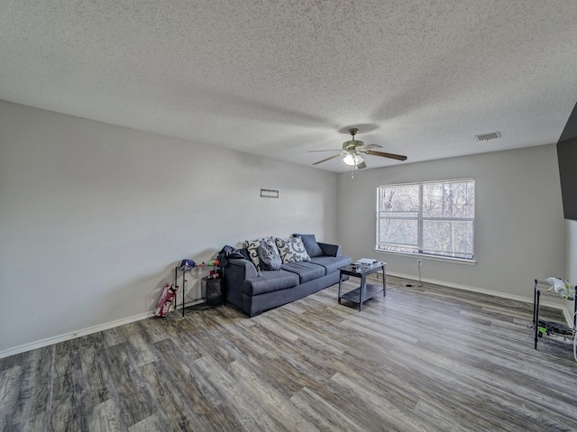 unfurnished living room featuring ceiling fan, wood-type flooring, and a textured ceiling