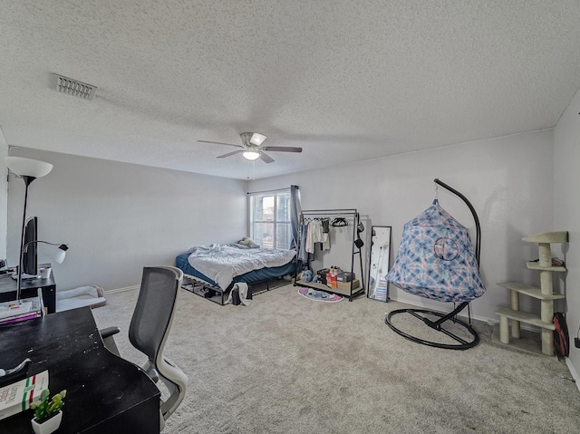 carpeted bedroom featuring a textured ceiling and ceiling fan