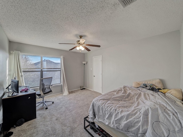 carpeted bedroom featuring a textured ceiling and ceiling fan