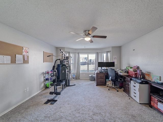 office area with ceiling fan, light colored carpet, and a textured ceiling