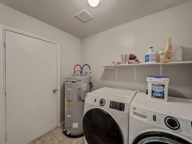 washroom with washer and dryer, a textured ceiling, light tile patterned floors, and water heater