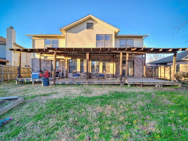 back of property with a wooden deck and a yard