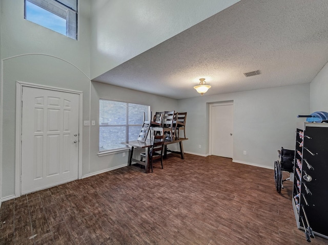 foyer entrance featuring a textured ceiling and dark hardwood / wood-style flooring