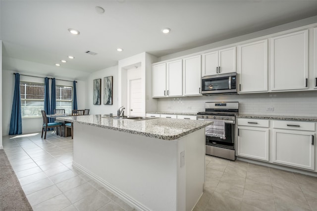 kitchen featuring white cabinets, sink, an island with sink, and appliances with stainless steel finishes