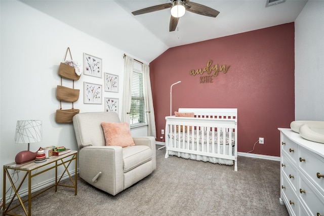 carpeted bedroom with ceiling fan, a nursery area, and lofted ceiling