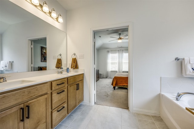 bathroom with tile patterned flooring, vanity, ceiling fan, and a tub