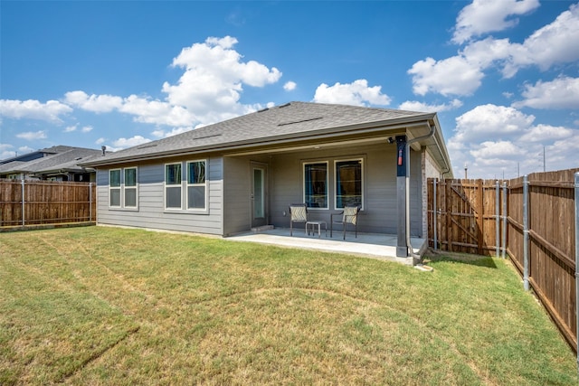 back of property with a lawn and a patio