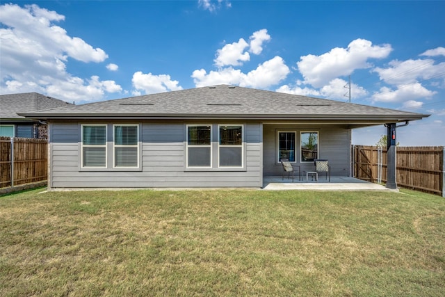 back of property with a yard and a patio