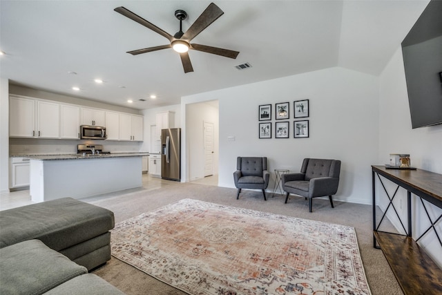 living room with ceiling fan, light colored carpet, and lofted ceiling