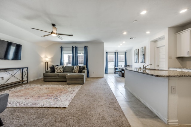 tiled living room featuring ceiling fan, a healthy amount of sunlight, and lofted ceiling