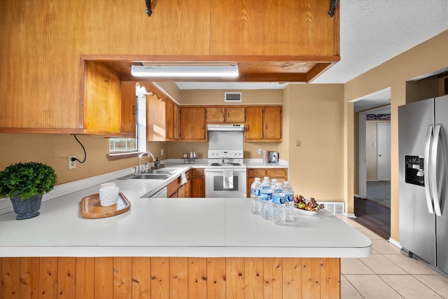 kitchen featuring stainless steel refrigerator with ice dispenser, electric stove, sink, and kitchen peninsula