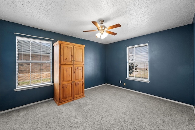 unfurnished bedroom featuring a textured ceiling, ceiling fan, and carpet flooring