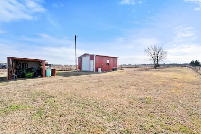 view of yard with an outbuilding, a rural view, and a garage