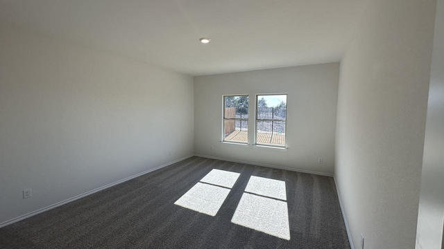 unfurnished room with dark carpet