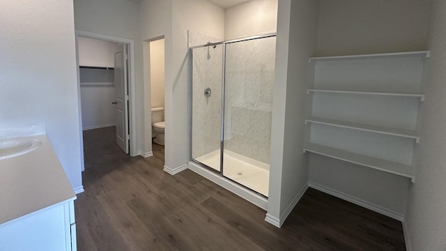 bathroom with sink, walk in shower, hardwood / wood-style floors, and toilet