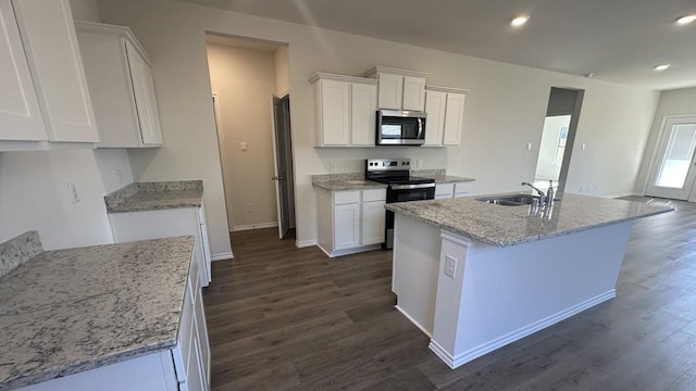 kitchen featuring dark wood-type flooring, stainless steel appliances, a kitchen island with sink, white cabinetry, and sink