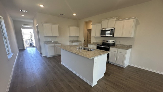 kitchen with sink, stainless steel appliances, a center island with sink, and white cabinetry