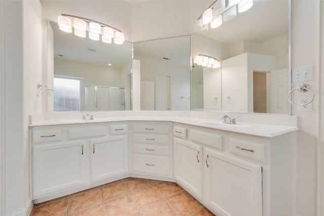 bathroom with tile patterned flooring, vanity, and walk in shower