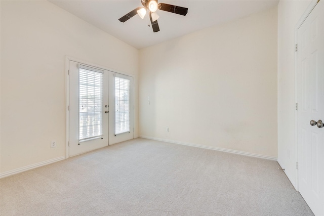 carpeted spare room featuring ceiling fan and french doors