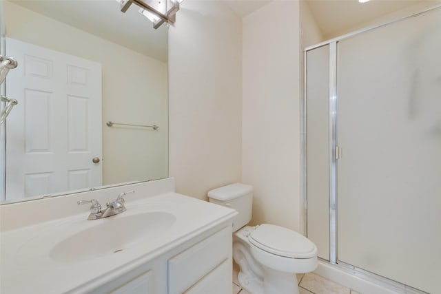 bathroom featuring toilet, vanity, tile patterned floors, and a shower with shower door