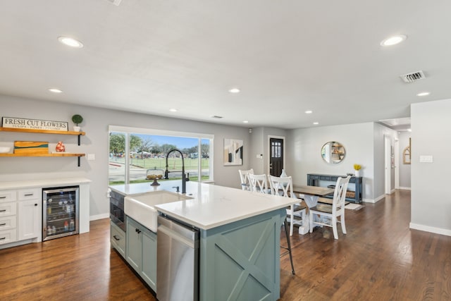 kitchen featuring dishwasher, a center island with sink, wine cooler, dark hardwood / wood-style flooring, and sink