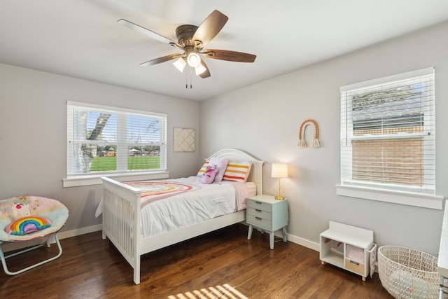 bedroom featuring ceiling fan, multiple windows, and dark hardwood / wood-style floors