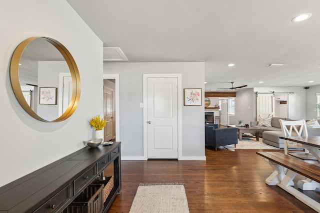 foyer entrance with dark wood-type flooring and a barn door