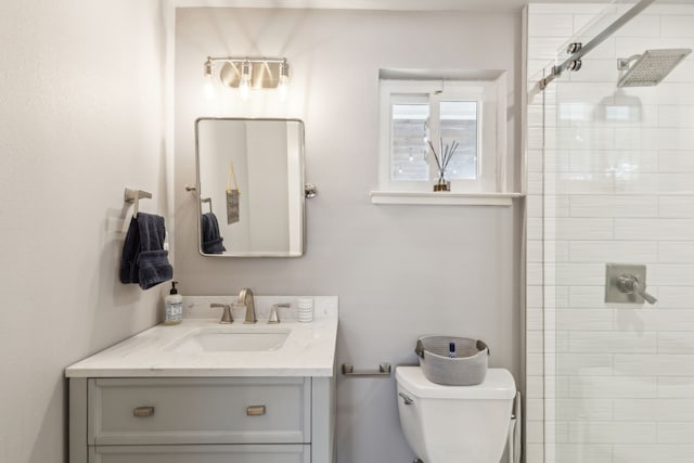 bathroom featuring toilet, a shower with door, and vanity