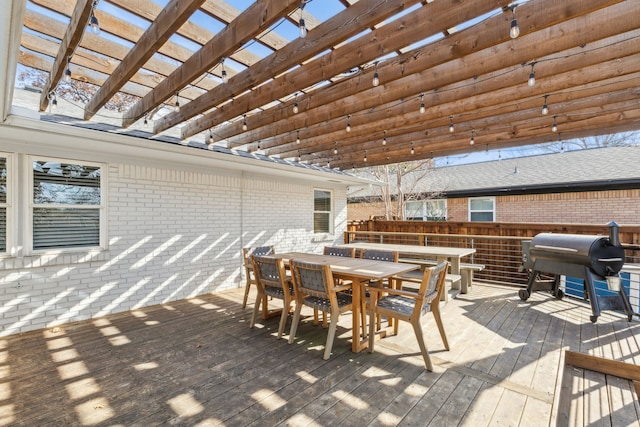 wooden deck with area for grilling and a pergola