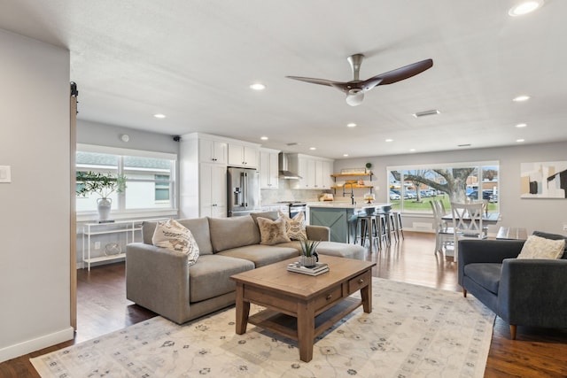 living room featuring sink, ceiling fan, and light hardwood / wood-style floors