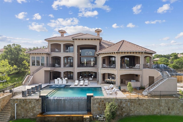 rear view of house with a fenced in pool and a patio area