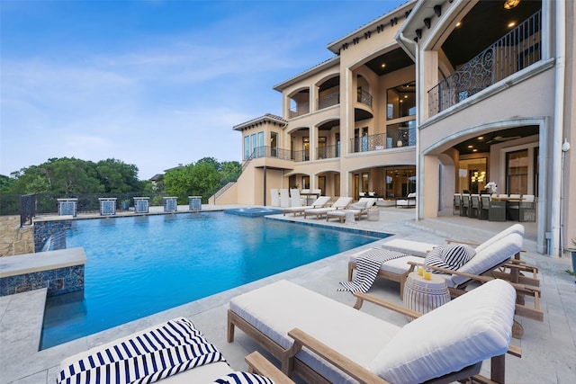 view of swimming pool featuring pool water feature and a patio