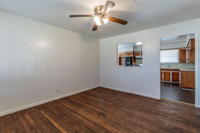 spare room featuring dark hardwood / wood-style floors and ceiling fan