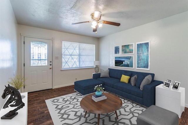 living room featuring a textured ceiling, dark hardwood / wood-style floors, and ceiling fan