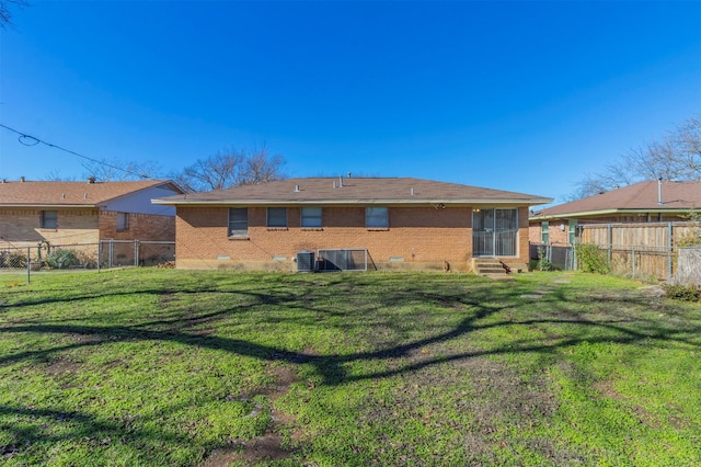 back of house featuring a lawn and cooling unit