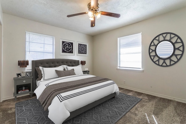 bedroom featuring ceiling fan, dark carpet, and a textured ceiling