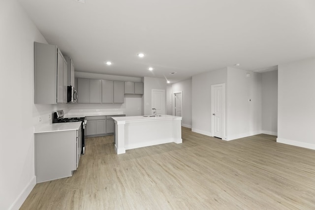 6721 Golden Grove Rd, Fort Worth, TX 76123 - kitchen featuring gray cabinetry, appliances with stainless steel finishes, a sink, light wood-style floors, and baseboards