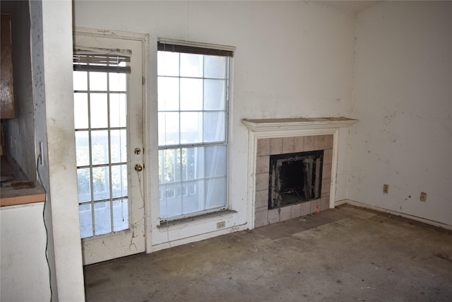 unfurnished living room with a tiled fireplace