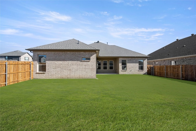 rear view of property featuring a lawn