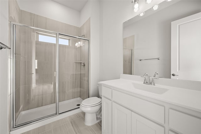 bathroom featuring walk in shower, vanity, tile patterned floors, and toilet