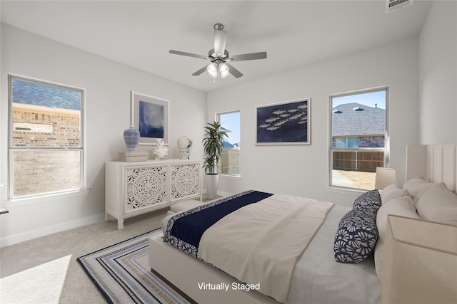 carpeted bedroom with ceiling fan, multiple windows, visible vents, and baseboards