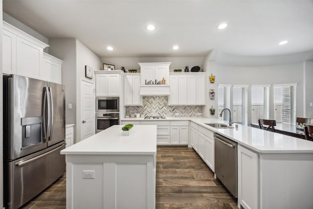 kitchen featuring white cabinetry, sink, a center island, and appliances with stainless steel finishes