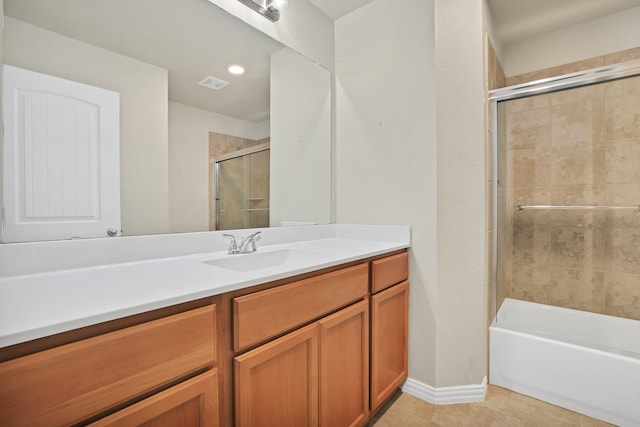 bathroom with tile patterned flooring, tiled shower / bath, and vanity