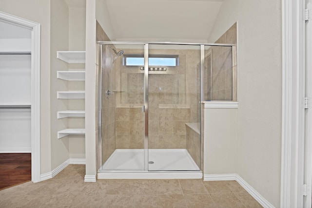 bathroom with lofted ceiling and a shower with shower door