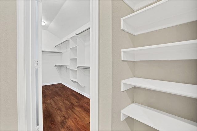 spacious closet with wood-type flooring and vaulted ceiling