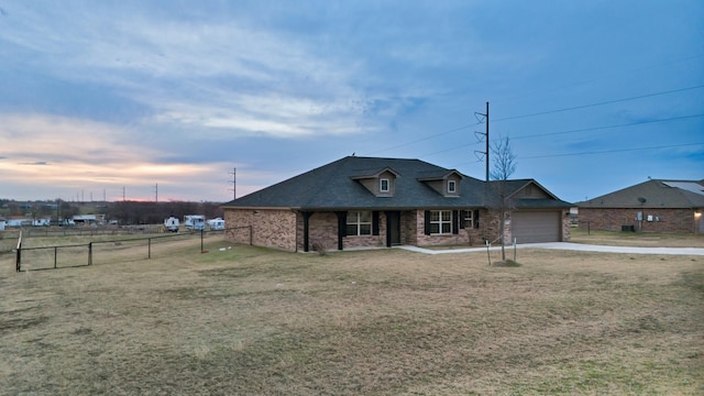 view of front of home with a garage and a lawn